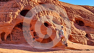 Valley of Fire - Woman standing next to beehives red sandstone rock formations along White Domes Hiking Trail, Nevada, USA