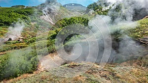 Valley of geysers. Kamchatka. Steam and smoke from fumaroles rise above the ground.