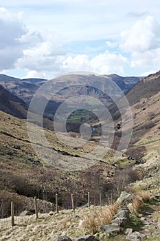 Valley in Lake District Cumbria, UK; green farmland in distance and fence in foreground