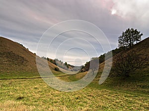 Valley between small hills under dark clouds