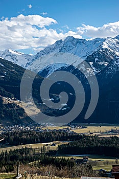 Valley with snowy mountains, meadows and village in Austria