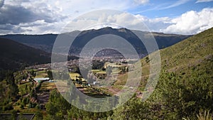 Valley with trees and houses with city in the background