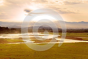 Valley view with river and mountains in the background at sunrise