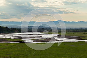 Valley view with river and mountains in the background at sunrise