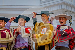 VALPARAISO, CHILE - SEPTEMBER, 15, 2018: Young tourists wearing hats and Chilean fabrics in front of a Monument To The