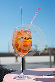 Aperol Spritz in glass on restaurant terrace in front of the beach