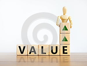 Value growth symbol. Concept word `value` on cubes on a beautiful wooden table. Wooden model of human . Beautiful white backgrou