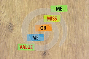 Value or miss me symbol. Concept words Value me or miss me on colored paper. Beautiful wooden table wooden background. Business