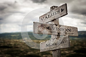 Values, vision, mission vintage wooden signpost in nature. photo