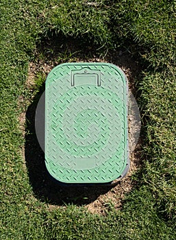 Valve box cover in green grass