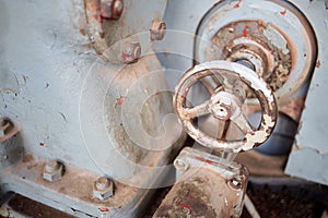 Valve on housing of heavy industrial machine pump or compressor of petrochemical production retro design painted with red and gray