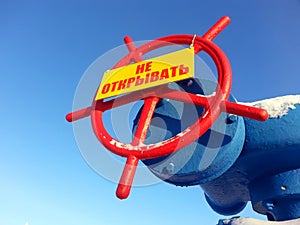 The valve with a warning sign on blue sky background