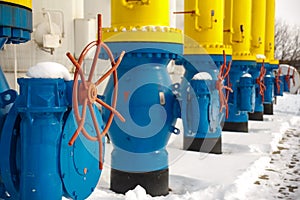 The valves for opening and closing the gas supplying at the gas compressor station in winter. Blue tubes for gas