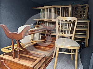 A van full of wooden chairs and furniture