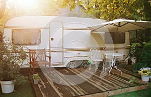 Van mobile home with terrace at sunset in autumn, mobile home, green and orange leaves