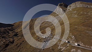 Van motorhome drive on serpentine in rocky mountains aerial Rbbro. Road trip on two recreational
