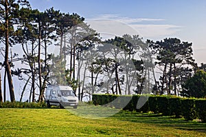 Van on the parking lot in the nature. Road trip concept. Campervan parking. Campsite.
