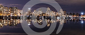 A night long exposure photo of marina inside Burrard Inlet of Vancouver Harbor with many boats