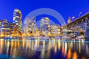 Vancouver BC skyscrapers and Granville Bridge reflection along False Creek at blue hour