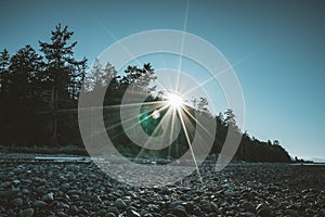 Vancouver Island beach view on a clear blue sky with sunstar and pacific coast. Canada.