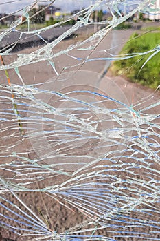 Vandalised Broken bus stop in the city. Dangerous, crashed tempered glass pieces on ground