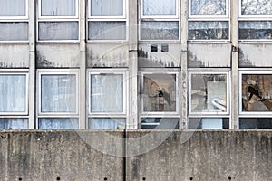 Vandalism, broken windows of a dilapidated council flat housing