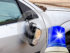 Vandalism on the exterior mirror of a car with flashing lights