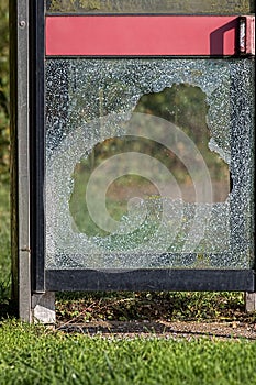 Vandalism with smashed glass on British telephone box. Anti-social behaviour.