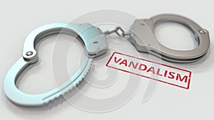 VANDALISM stamp and handcuffs. Crime and punishment related conceptual 3D rendering