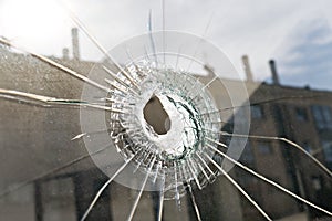 Vandalism or violence concept. Broken glass with hole