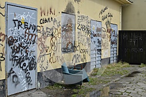 Vandalized graffiti wall and two modern armchairs photo