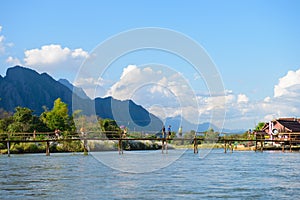 Vang Vieng, Laos - November 13, 2014 : Toursit activies with wooden bridge over Song river in Vangvieng, Vang Vieng is a tourist