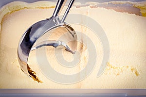 Vanill ice cream being scooped by a mechanical scoop