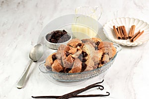 Vanilla Bread and Butter Pudding with Raisins in Clear Baking Dish, Served with Vla