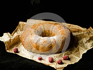 Vanilla bundt cake with fresh raspberries on a black table. vegetarian, lean, dairy and egg free. Selective focus. Close