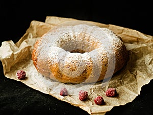 Vanilla bundt cake with fresh raspberries on a black table. vegetarian, lean, dairy and egg free. Selective focus. Close