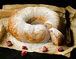 Vanilla bundt cake with fresh raspberries on a black table. vegetarian, lean, dairy and egg free. Selective focus. Close