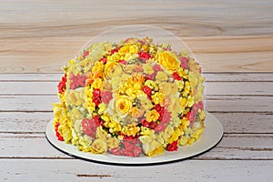 Vanilla cake decorated with kalanchoes and begonias flowers