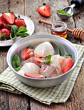 Vanilla and chocolate ice cream with organic strawberries. Rustic style.