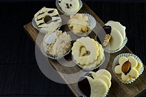 Vanilla cookies with different shapes on wood and black background photo