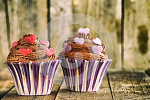 Vanilla cupcake with chocolate topping. Old wooden background.