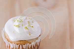 Vanilla cupcake with white frosting and flowers on a table