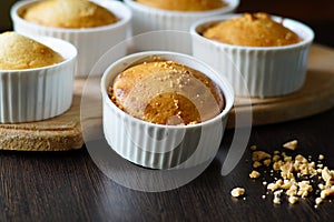 Vanilla cupcakes in a form on a wooden board