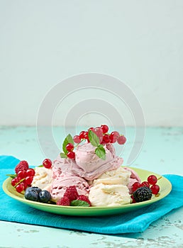 Vanilla ice cream balls with red raspberries in a round plate