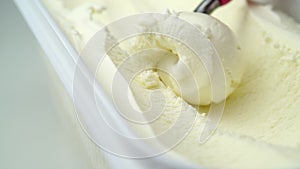 vanilla ice cream being scooped out of container