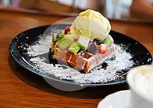 Vanilla ice cream with berries, strawberries, blueberries, raspberries, apple on waffle with powdered sugar. Summer food concept