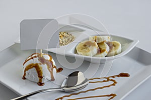 Vanilla ice cream with caramel sauce on a white plate with blank label