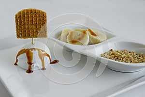 Vanilla ice cream with caramel sauce on a white plate with blank waffle label