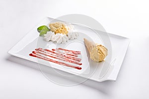 Vanilla ice cream cone with berry sauce and meringue on plate  on white background