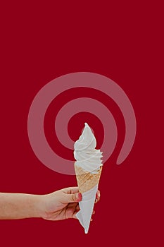 Vanilla ice cream cone hold by hand